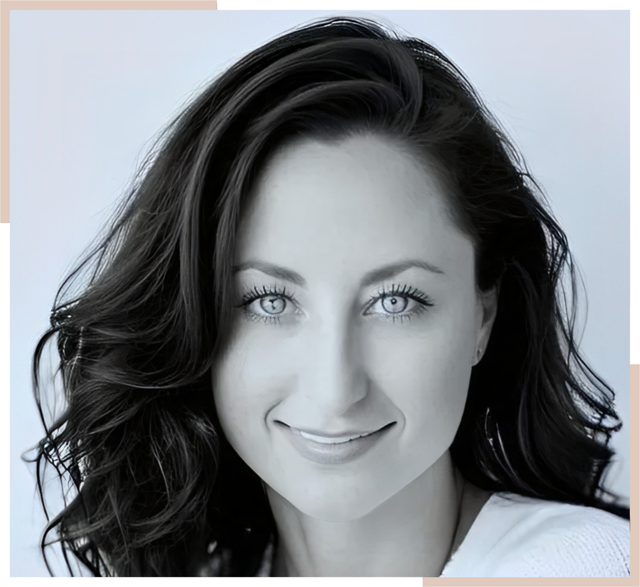 Portrait of a woman with long dark hair, smiling softly and looking directly at the camera against a plain background.
